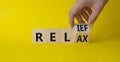 Relief and relax symbol. Hand turns cubes and changes the word Relief to Relax. Beautiful yellow background. Businessman hand. Royalty Free Stock Photo