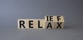 Relief and relax symbol. Turned cubes with words Relief and Relax. Beautiful grey background. Business and Relief and relax