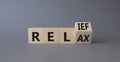 Relief and relax symbol. Turned wooden cubes with words Relief and Relax. Beautiful grey background. Business and Relief and relax