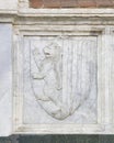 Relief of a shield with a heraldic lion in rampant position on the outside of the Basilica Santa Maria Novella in Florence.