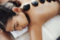 Relieving everyday stress with stones. a young woman getting a hot stone massage at a spa. Royalty Free Stock Photo