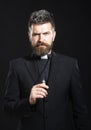 Religion concept. Handsome hispanic catholic priest man over black isolated background. Pastor or preacher praying