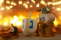 Religion concept of of jewish holiday Hanukkah with wooden dreidels spinning top and chocolate coins over wooden table and bokeh Royalty Free Stock Photo