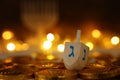 Religion concept of of jewish holiday Hanukkah with wooden dreidels spinning top and chocolate coins over wooden table and bokeh Royalty Free Stock Photo