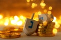 Religion concept of of jewish holiday Hanukkah with wooden dreidels spinning top and chocolate coins over wooden table and bokeh Royalty Free Stock Photo