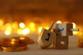 Religion concept of of jewish holiday Hanukkah with wooden dreidels spinning top and chocolate coins over wooden table and bokeh Royalty Free Stock Photo