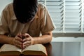 Religion concept, Young asian man reading bible and raising hands to prayer for believe in goodness Royalty Free Stock Photo