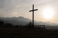 Religion theme, view of catholic cross silhouette, with fantastic sunset and mountains as background. Toned image Royalty Free Stock Photo