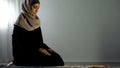 Religious arab woman sitting on islamic praying rug, religious worship, faith