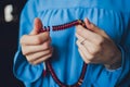 Religious Asian buddhist woman praying with hand holding rosary beads. Female buddhist disciple meditating, chanting