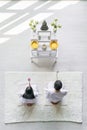 Asian couple wearing white clothing worship and praying to buddha statue together with holding lotus flowers in hands Royalty Free Stock Photo