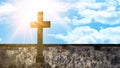 Religious background - Old stone cross and old brick stone wall in the cemetery with blue sky, clouds and sunbeams Royalty Free Stock Photo