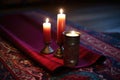 a religious candle next to a folded prayer mat