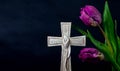 Ornate cross with tulips on a dark background. Condolence card. Place for text