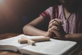 Religious Christian boy praying over Bible indoors