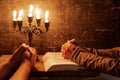 Religious female crossed hands in prayer with bible and candle Royalty Free Stock Photo