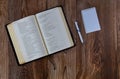 Religious christian opened Bible on wooden table with pen spiral notepad Royalty Free Stock Photo