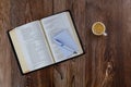 Religious christian reading opened Holy Bible on wooden table with pen spiral notepad cup of coffee Royalty Free Stock Photo