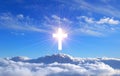 Religious cross over cumulus clouds illuminated by the rays of holy radiance, concept. Royalty Free Stock Photo