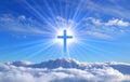 Religious cross over cumulus clouds illuminated by the rays of holy radiance, concept. Royalty Free Stock Photo