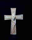 Isolated ornate religious cross with a flower on a dark background. Moment of grief at the end of a life. Last farewell. Royalty Free Stock Photo