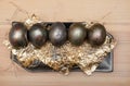 On the religious holiday of Easter, several dark golden handmade chicken eggs lie on a ceramic plate. Royalty Free Stock Photo