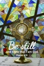Religious inspirational quote from bible verse psalm 4:10 - Be still and know that I am God. With Eucharistic adoration chapel. Royalty Free Stock Photo