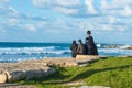 Religious family sitting on the coast of Mediterranean sea in Israel and watching the waves. Sunset beach, family rest traditi