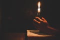 Religious man holding lit candles on the Holy Bible and praying in the Church, Royalty Free Stock Photo