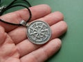 Religious metal symbol medallion in hand