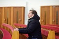 Religious middle age man praying and meditating in catholic church. Person begging for forgiveness and blessing from God Royalty Free Stock Photo