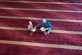 Religious Muslim Man teaching his little son to pray to God with Koran and rosary at mosque during ramadan Royalty Free Stock Photo