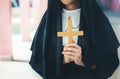 Religious nun in religion concept. Hands praying to the GOD while holding a crucifix symbol . Nun holding a cross in his hands. Royalty Free Stock Photo