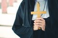 Religious nun in religion concept. Hands praying to the GOD while holding a crucifix symbol . Nun holding a cross in his hands. Royalty Free Stock Photo