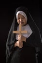 Nuns praying to the GOD while holding a crucifix symbol on black background Royalty Free Stock Photo