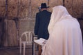 Religious orthodox Jew in the foreground wearing a prayer shawl draped prays at the Western wall, Jerusalem, Israel. Male figure Royalty Free Stock Photo