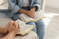 Religious people with Bibles praying together indoors, closeup Royalty Free Stock Photo