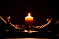 Book, candle and hands. Woman prays in dark. Reading prayers at night. Royalty Free Stock Photo