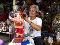 A religious shop owner fixes up a Child Jesus figurine