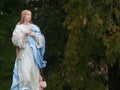 Religious Statue Iconography Mary in an Outdoor Setting with an Angel at her feet