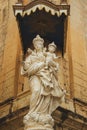 Religious statue of a mother and a child in front of an old building of Mdina Gate in Malta Royalty Free Stock Photo