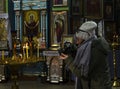 Ukraine, the village of Parkhomovka, Kharkiv region, February 8, 2020, a girl photographs candles in a church Royalty Free Stock Photo