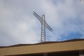 Religious white cross on decorative church rooftop against the sky background