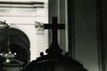 Religious wooden cross on a confessional in the dark interior of a Catholic church, with out of focus background, black and white Royalty Free Stock Photo