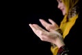 Religious young Muslim two women praying over black background.