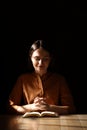 Religious young woman praying over Bible at wooden table indoors Royalty Free Stock Photo