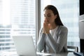 Religious female employee praying to god at workplace