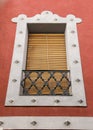 Whitewashed facade with window with forged metal grill