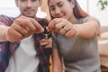 Relocation and beginning new life. Asian couple showing keys apartment after purchase and moving in new room together Royalty Free Stock Photo