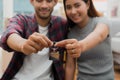 Relocation and beginning new life. Asian couple showing keys apartment after purchase and moving in new room together